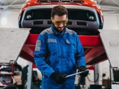 carrozziere che utilizza strumenti all'avanguardia per diagnosi su vetture